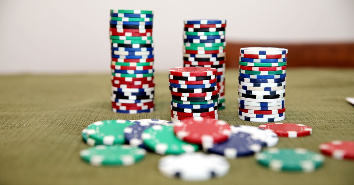 Stacks of colorful poker chips on a green table ready for a game.